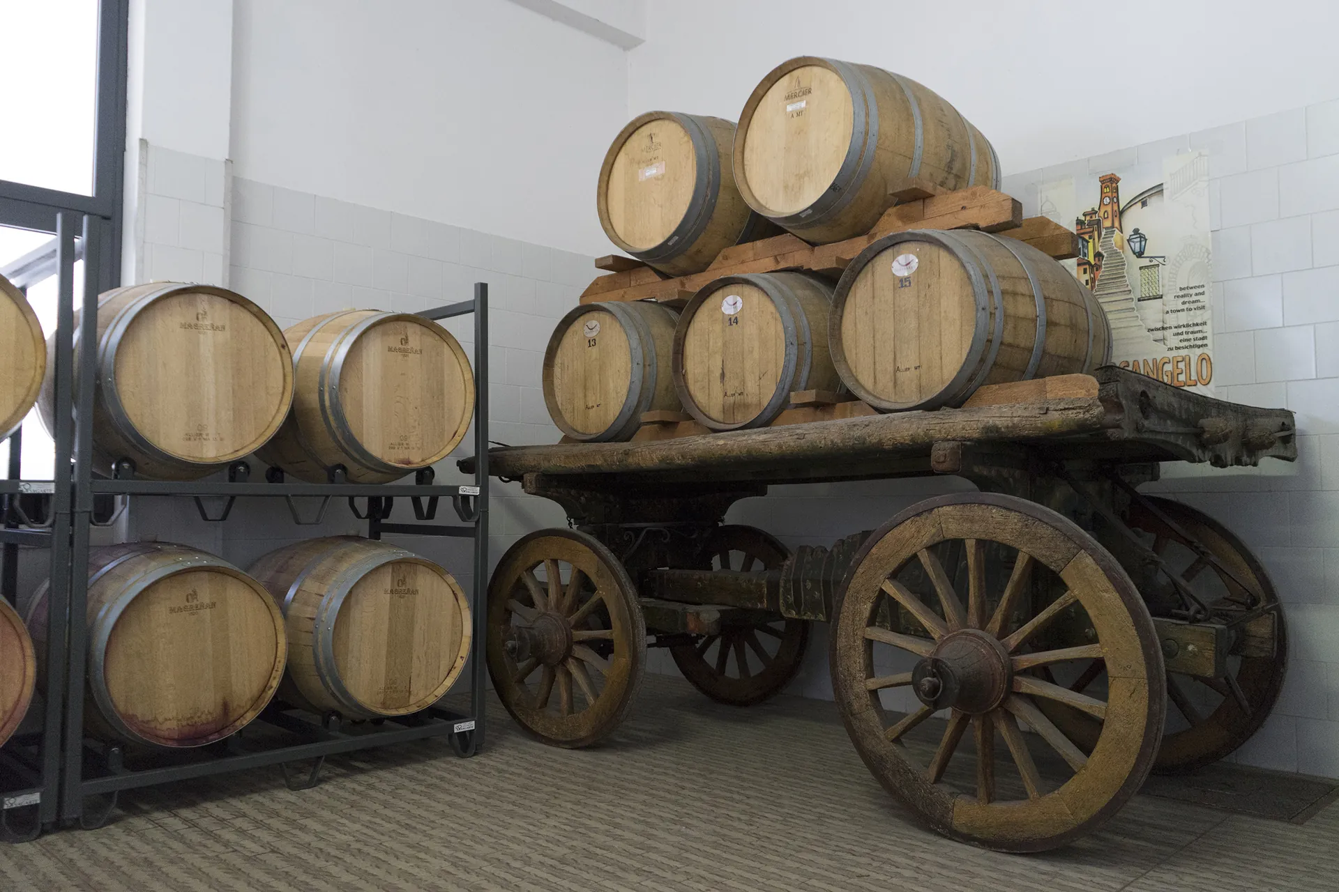 Barrique impilate sull'antico carro in cantina